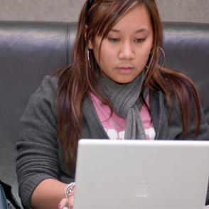 student works behind her laptop 