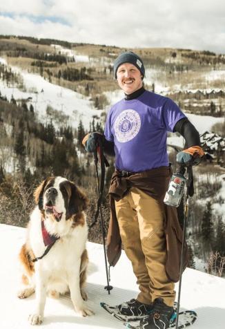 AdeventureEXP founder, Adam Salzman (rocking a Casa Nueva tee) on a snowy mountain with a St. Bernard