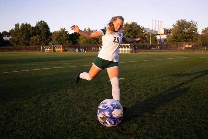 image of Regan Berg Sr soccer player kicking a blow up earth 