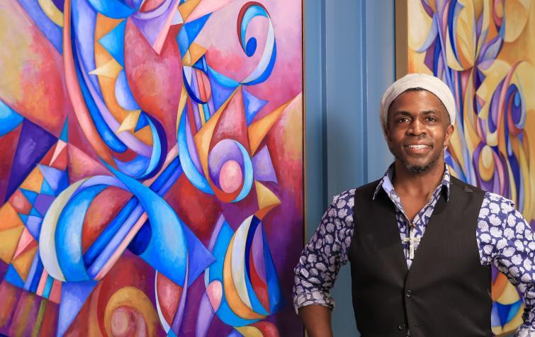 Photo of artist Cedric Michael Cox in front of his painting