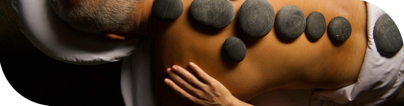 Massage client with hot stones on back