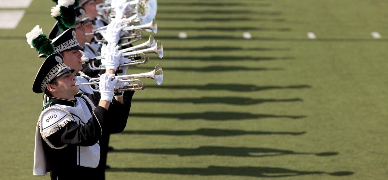 Marching 110 members perform trumpet on the field
