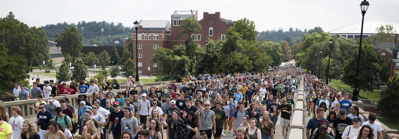 Hundreds of students walk through campus together during the first year convocation