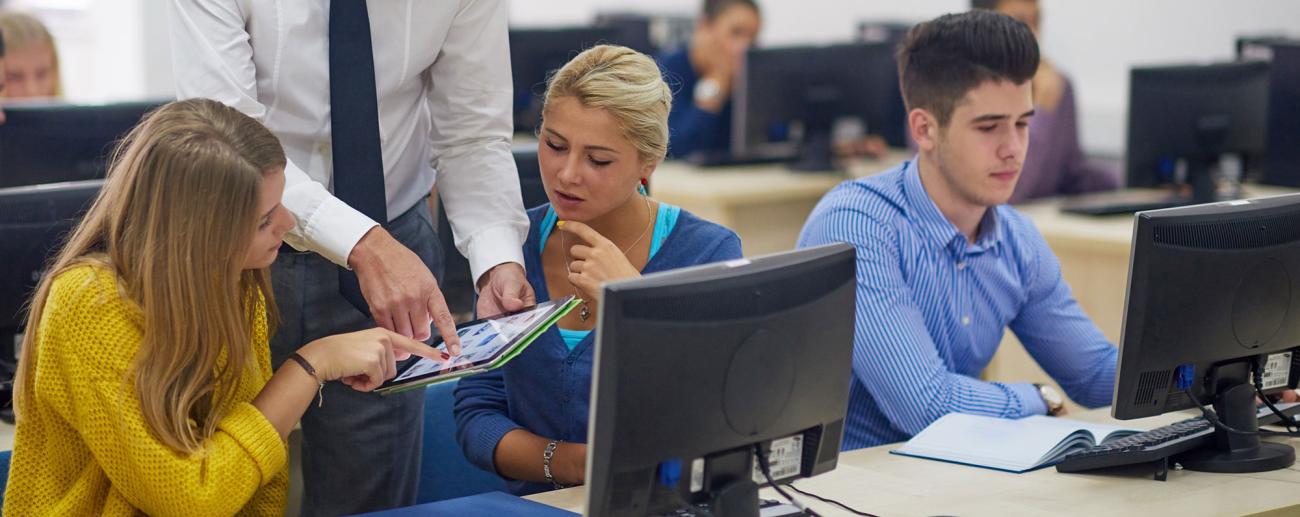 Higher ed professor and students interacting with computers