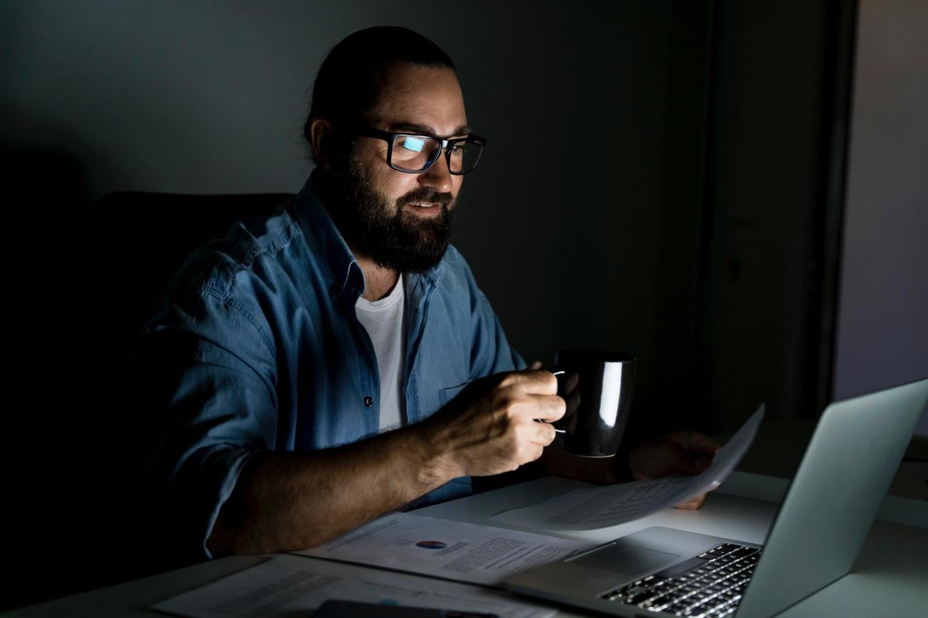 A man working on a computer at night. Image by Freepik.