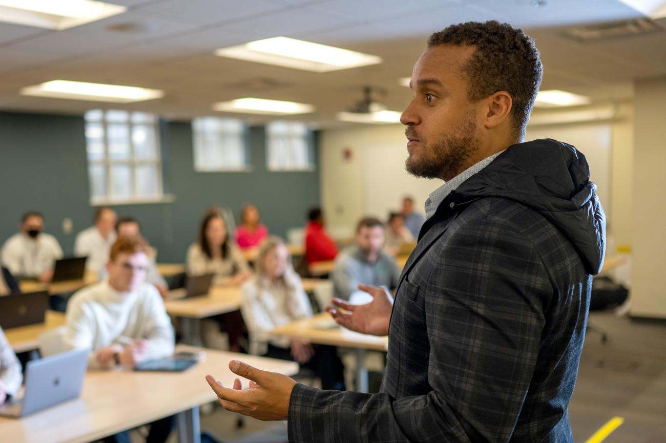 A man standing in front of a class speaking