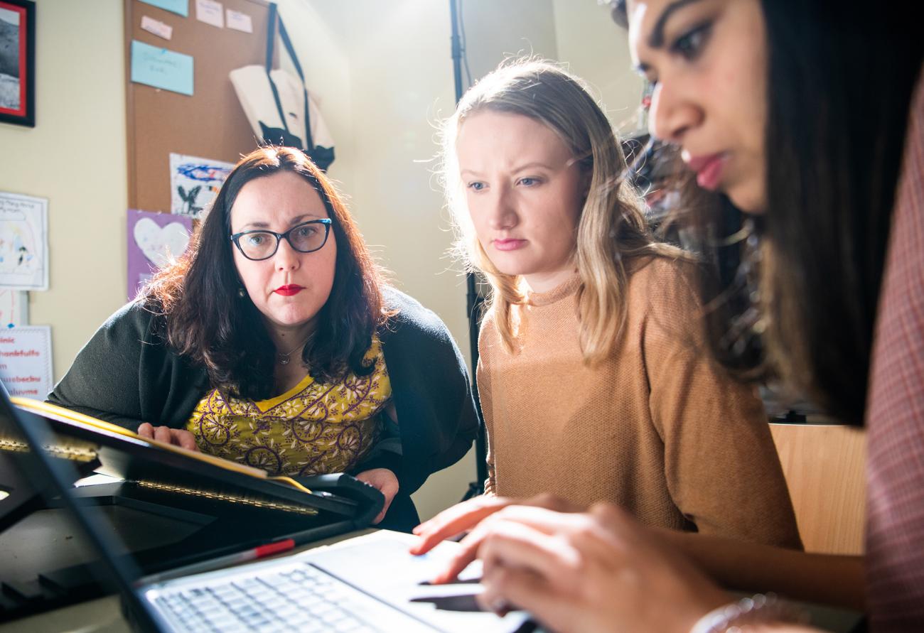 Three women working together on a computer