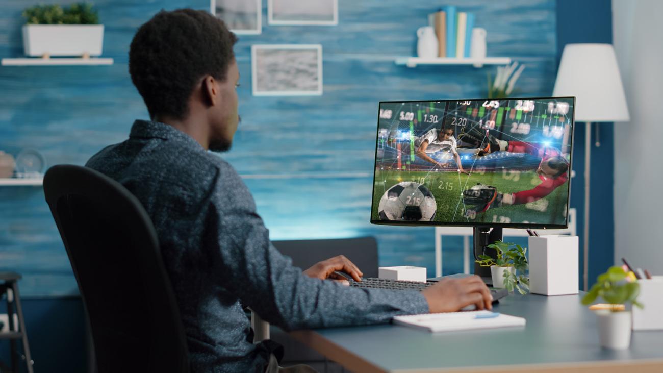 Man looking at graphic of soccer and some graphs overlayed 