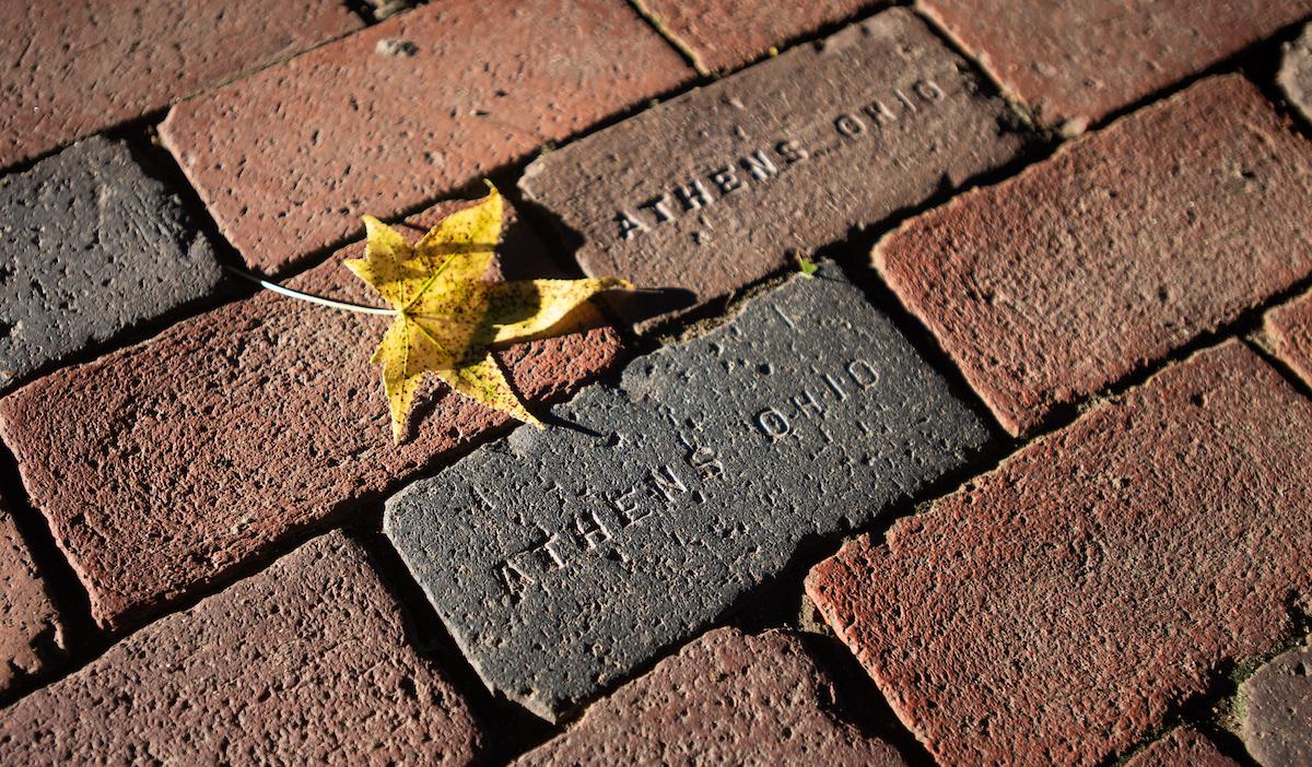 Yellow fall leaf laying on Athens, OH bricks.