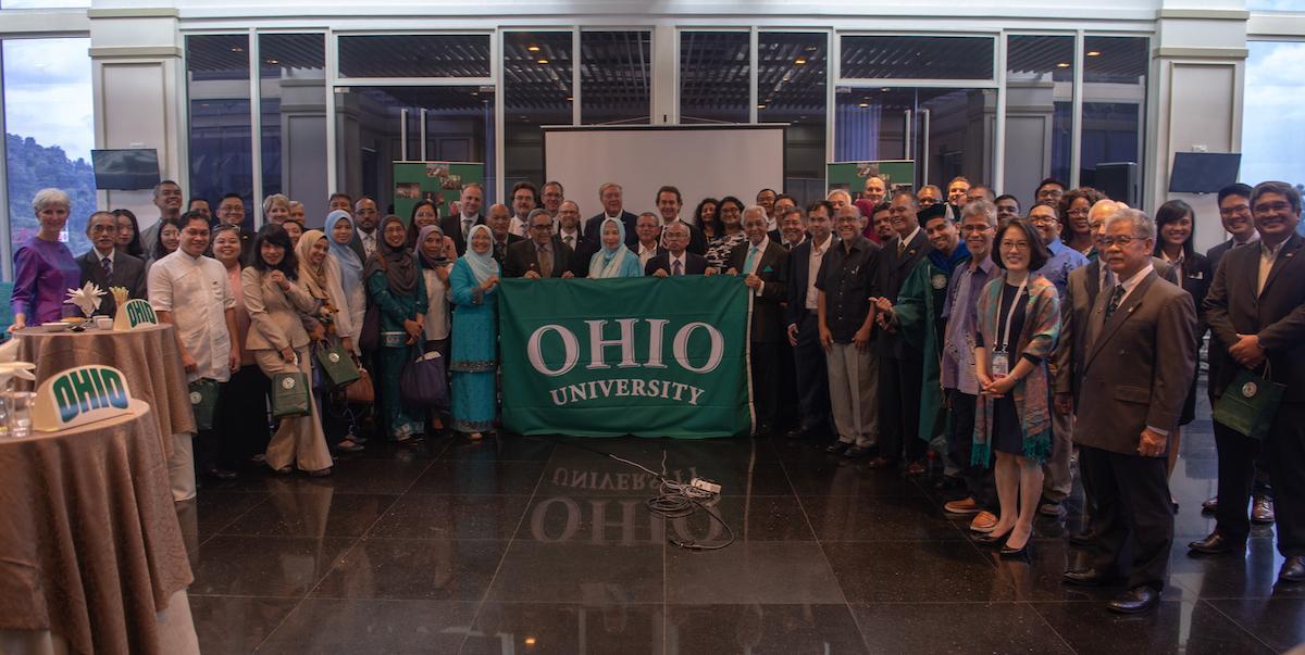 Attendees at the Razak Chair alumni event pose with the Ohio University banner