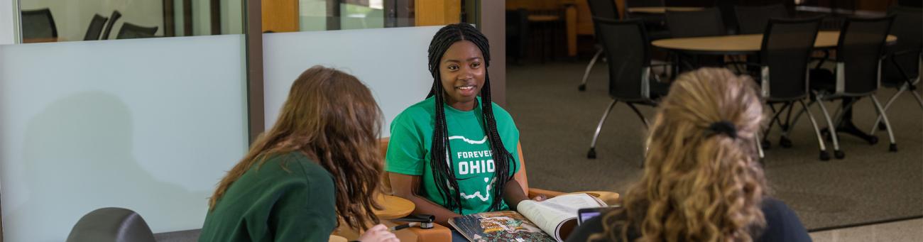 Students talk while sitting in an atrium at a regional campus.