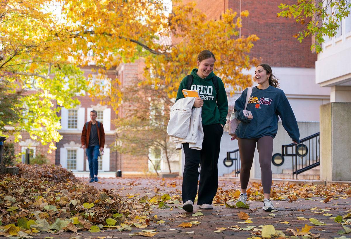Two students talk while walking by the Library on OHIO's Athens campus