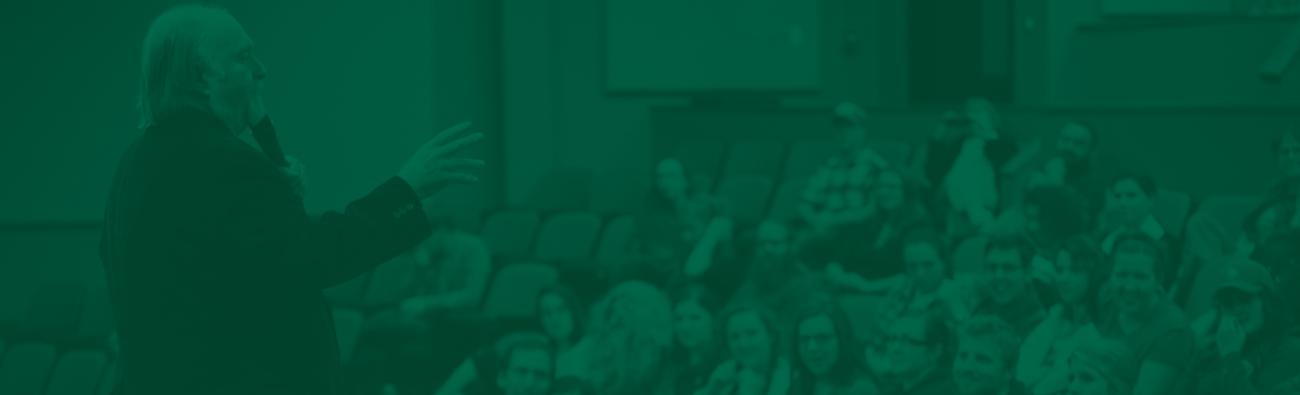 man on a stage talking to a diverse crowd