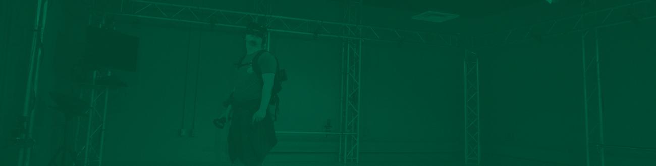 person in a green screen room using a VR headset