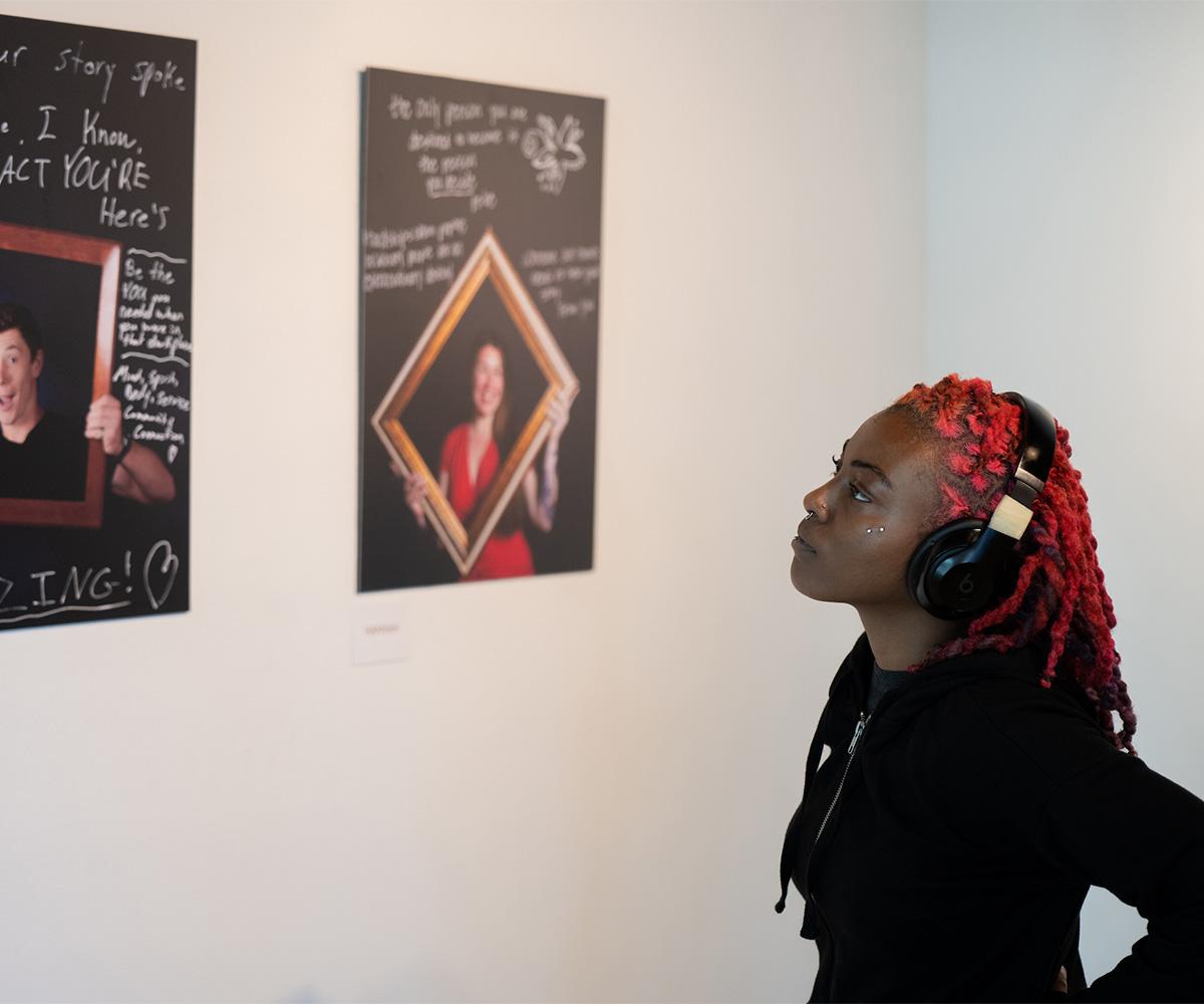 A student looks at art in an art gallery.