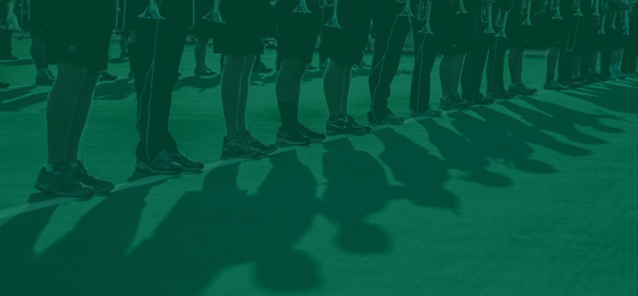 Members of the Marching 110 marching band line up on a practice field