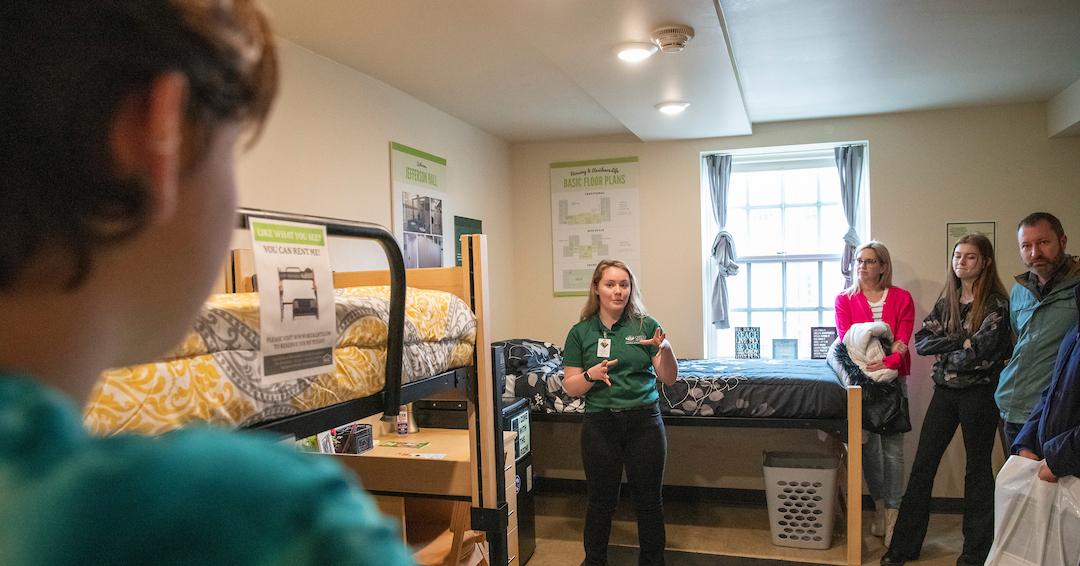 Summer Housing Ambassador showing a showroom to a family in the summer