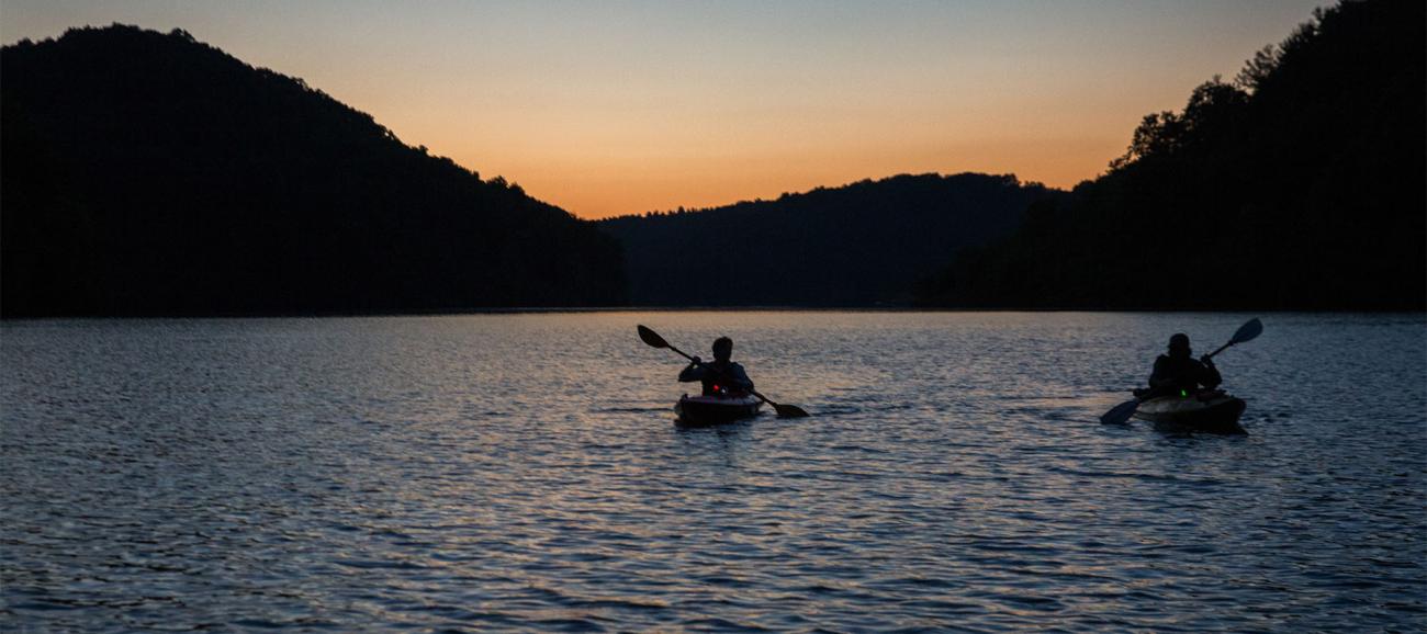 Two people kayak during the Moonlight Paddle at Strouds Run 