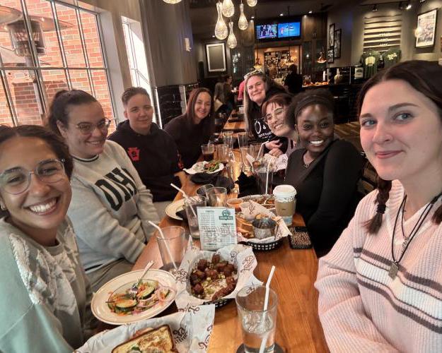 Students have a meal with a mentor.