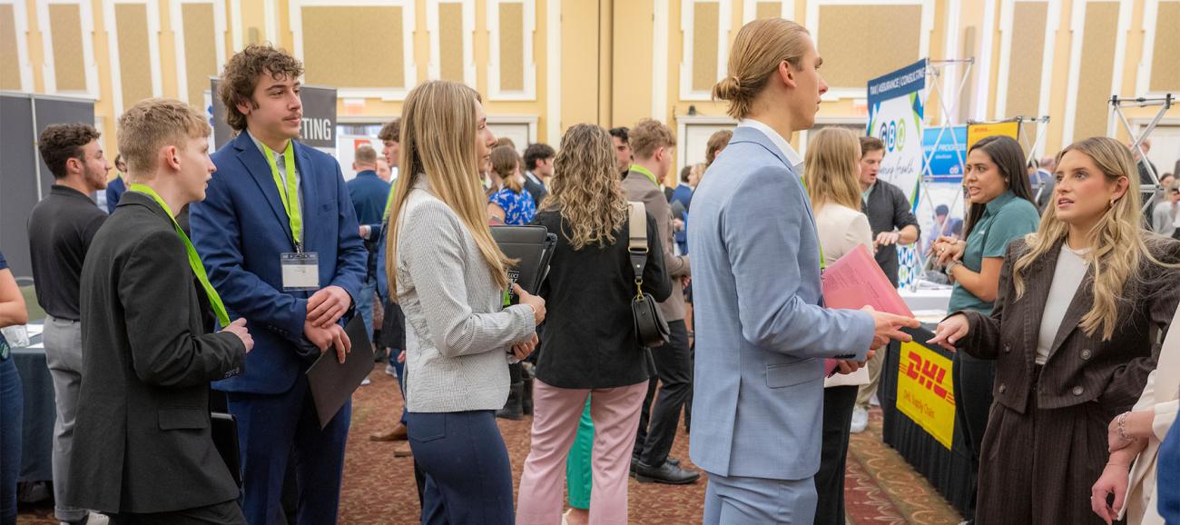 Students line up to talk to an employer at a career fair.