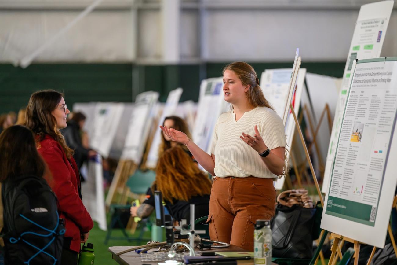 graduate student presents her research at a student expo