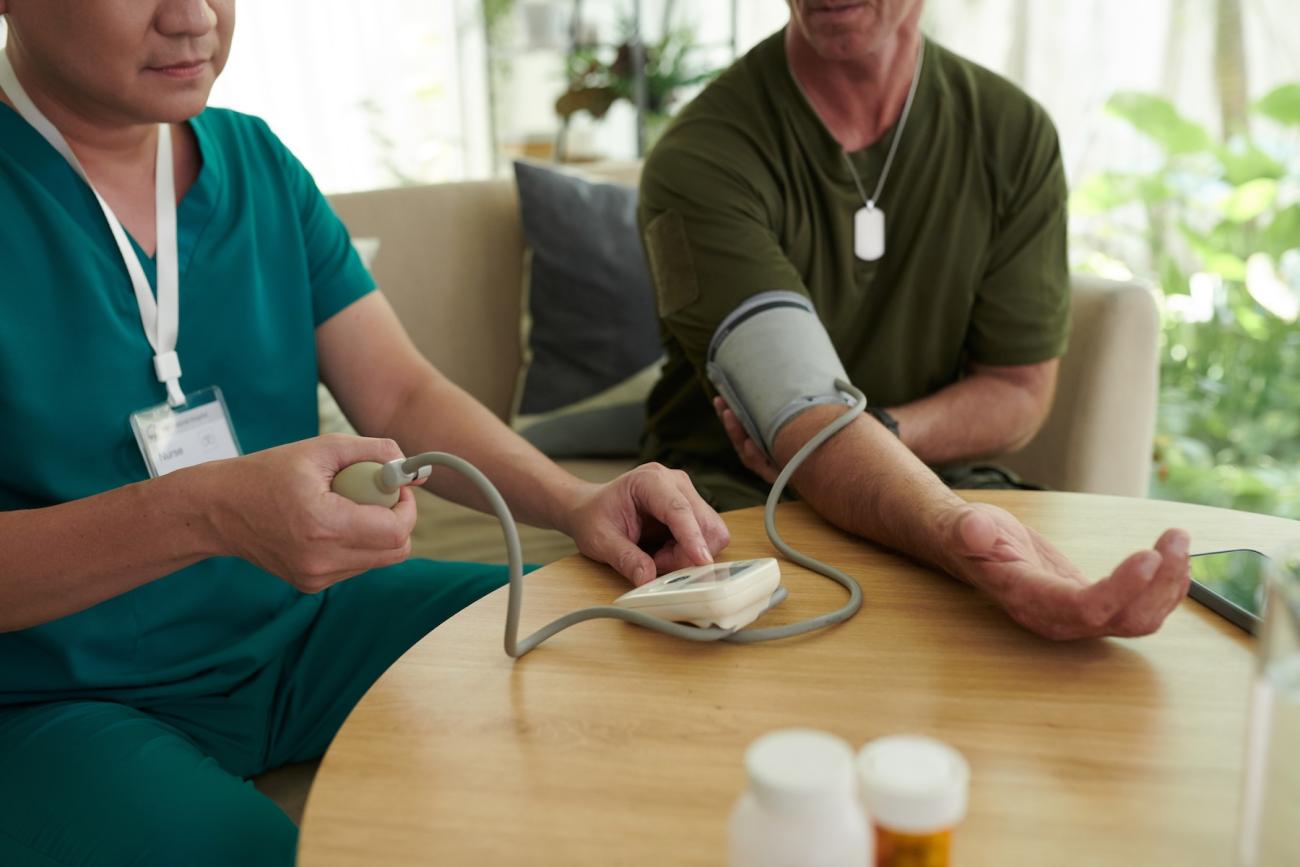 nurse checking veteran's blood pressure using a cuff