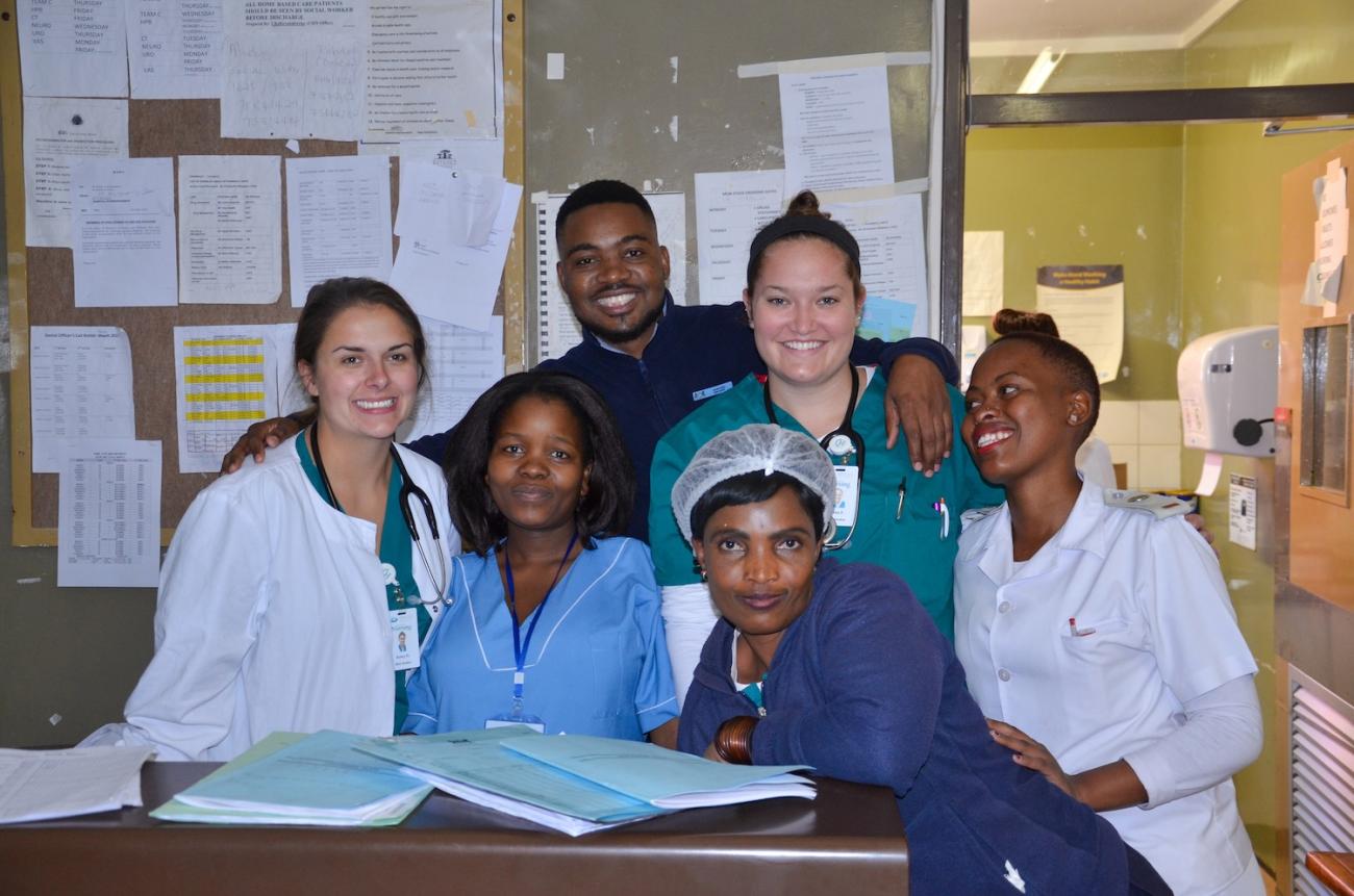 Two Ohio University healthcare workers in a medical setting in Botswana with local healthcare workers