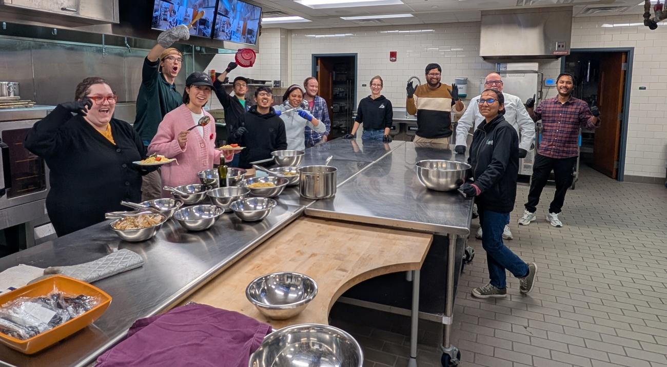 A group of graduate students cooking in an industrial kitchen