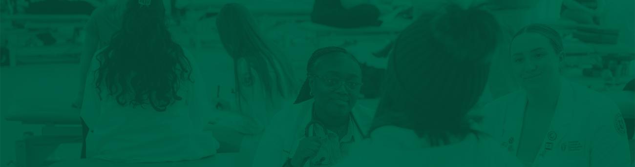 Two medical school students talk to a patient during a clinic.