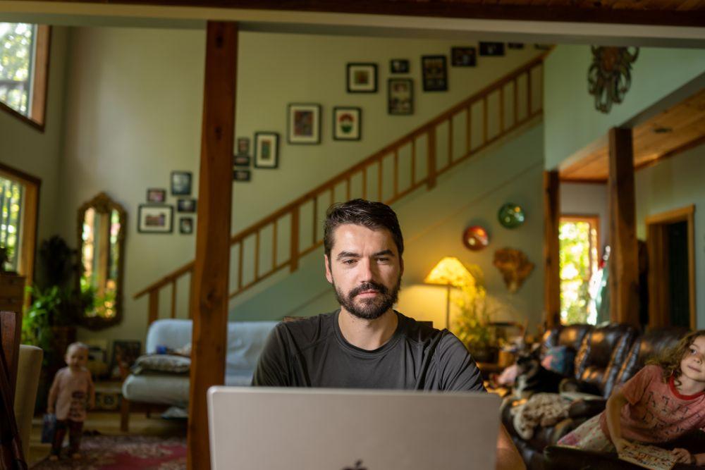 Man using laptop in home setting with decor in background