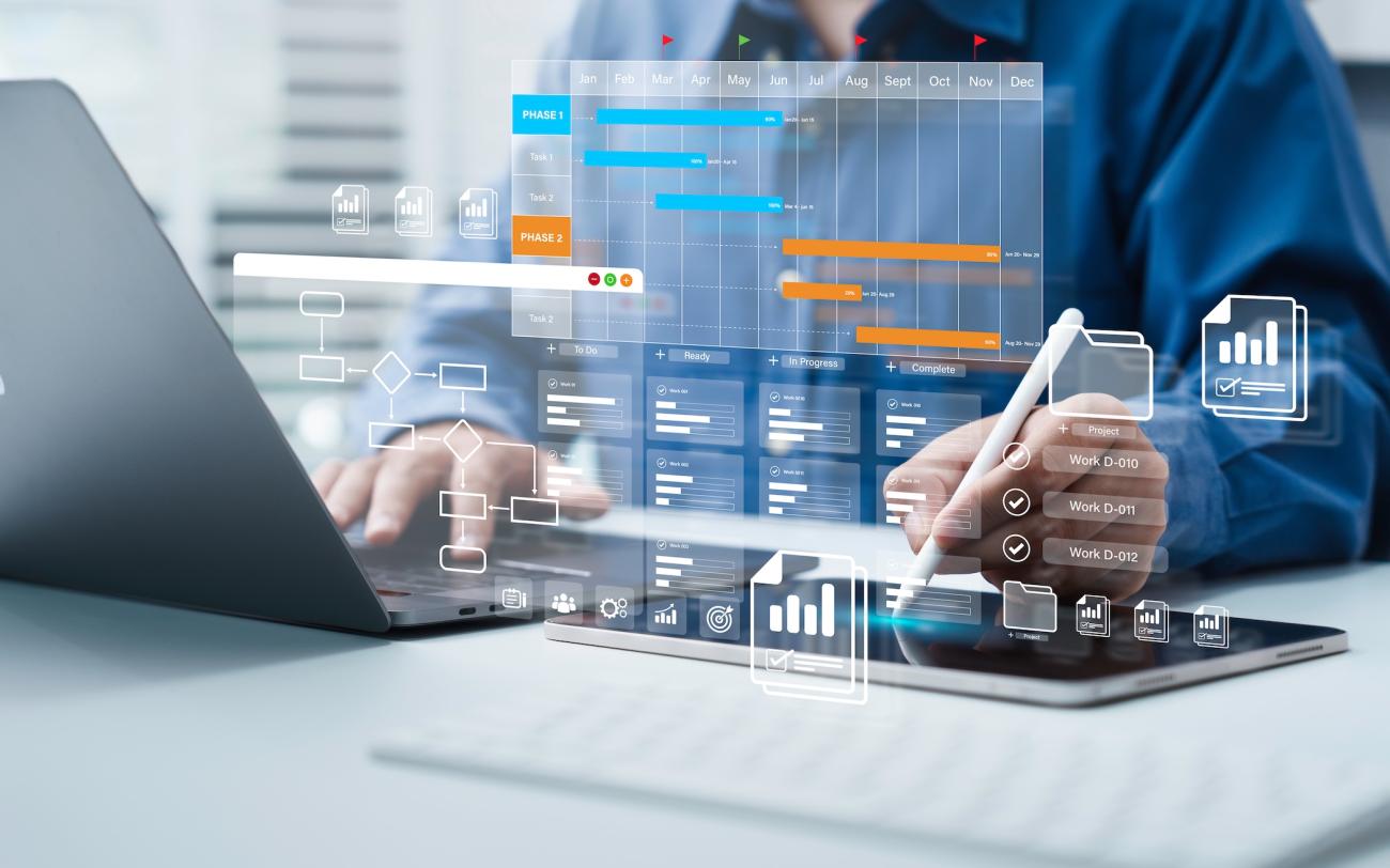illustration of charts and deadlines overlayed on top of an image of a person sitting at a desk with a laptop and tablet