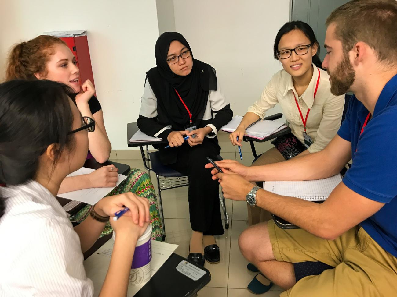 group of people sitting at desks and talking