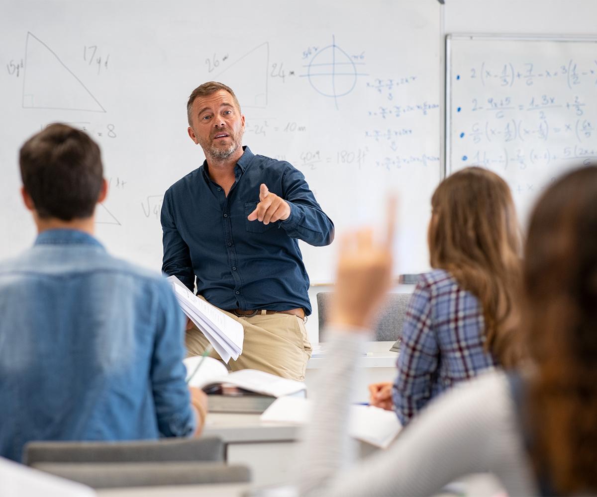 A stock image of a teacher talking to his students.