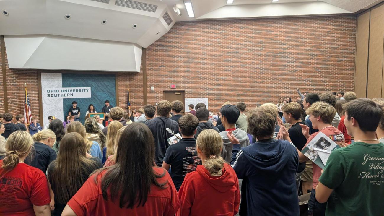 students standing in Bowman Auditorium looking toward stage