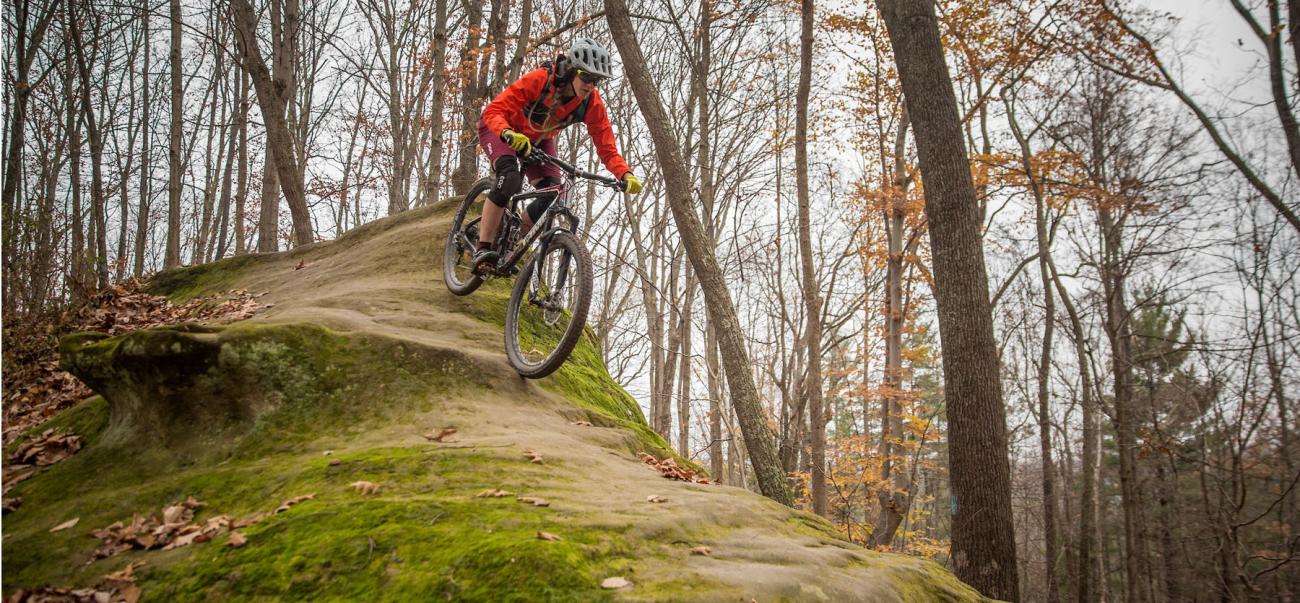 girl on dirt bike rides down a steep hill
