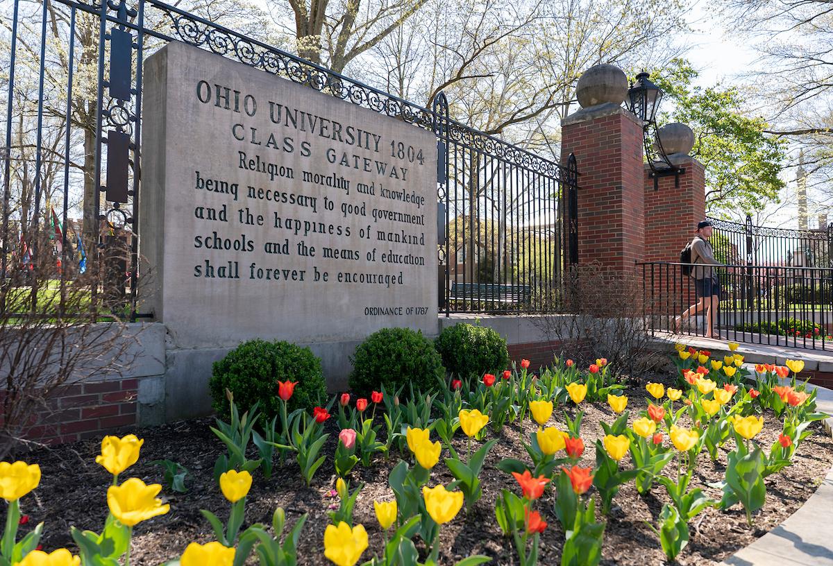 The Ohio University Alumni Gate surrounded by spring flowers. 