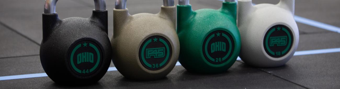 kettlebells for 45 in various weights laid neatly on the ground
