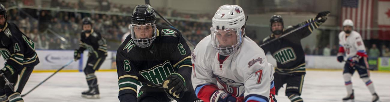 hockey players clash together competing for the puck