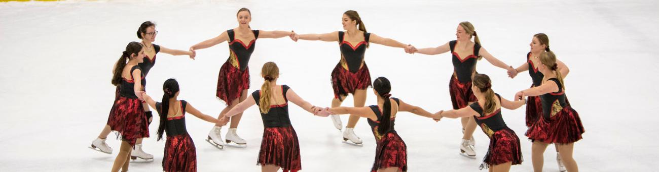group of professional skaters make a circle holding each other's hands 