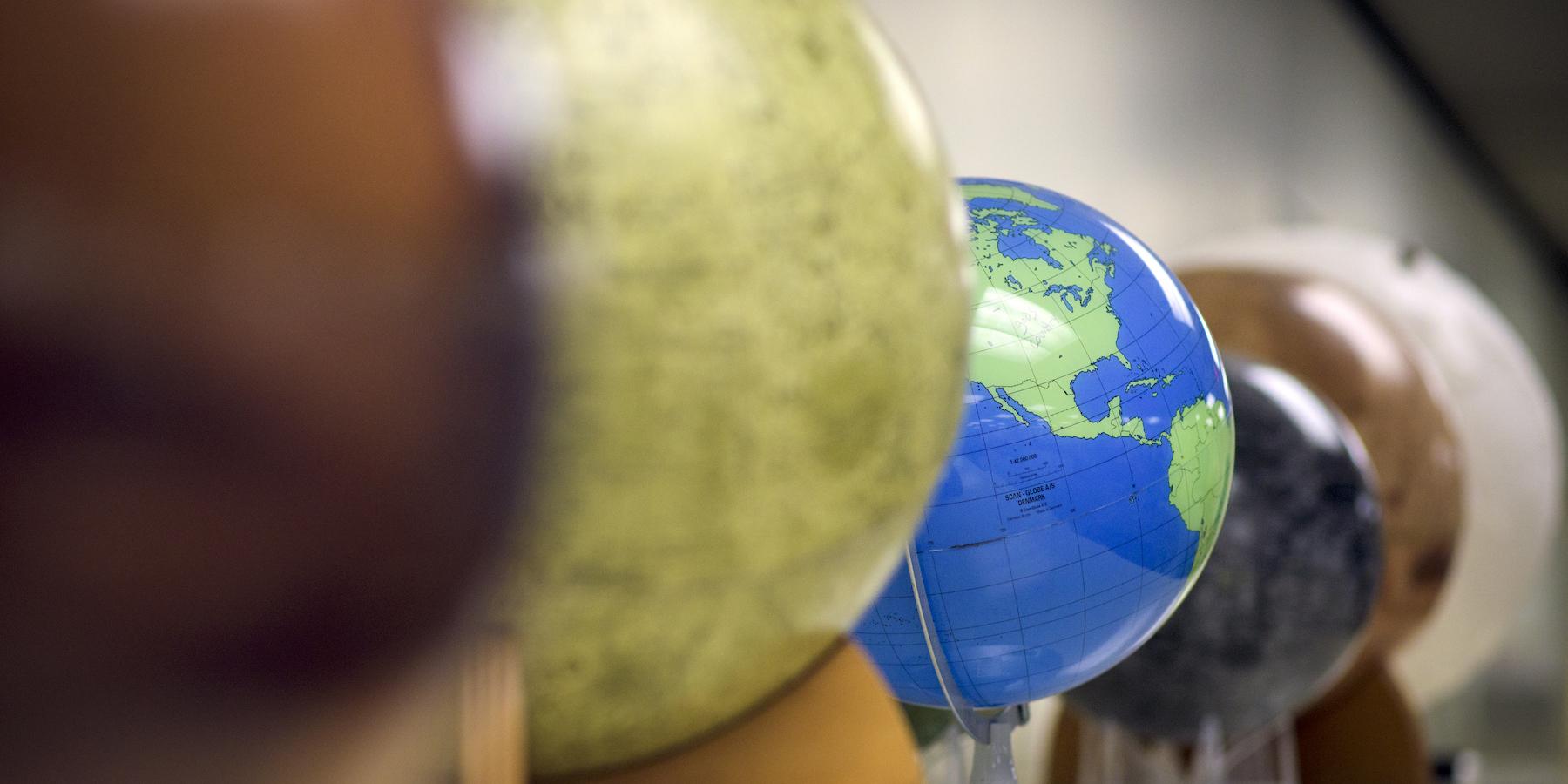 A blue and green Earth globe within a row of globes