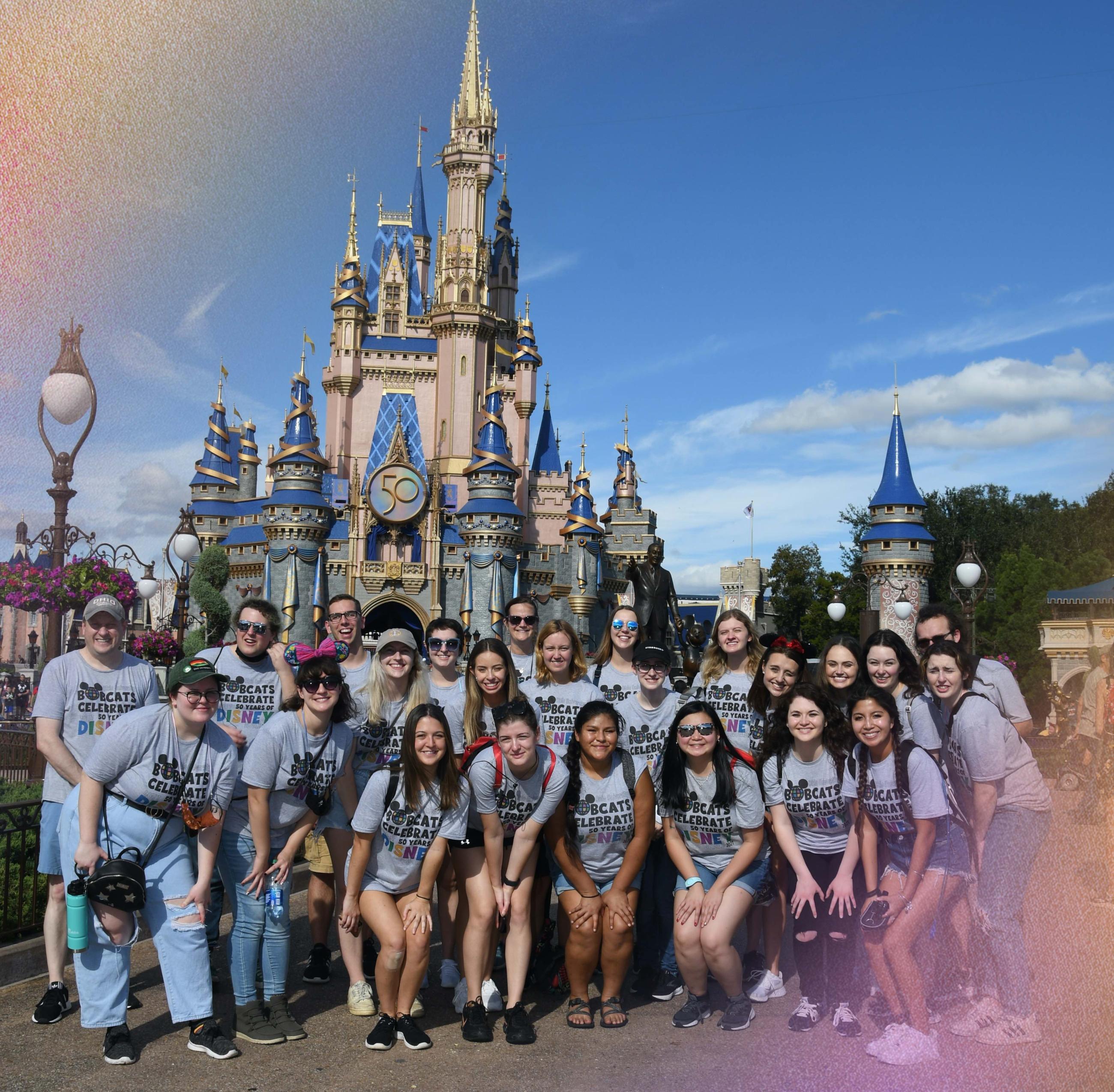 Group of students in front of the Disney castle. 