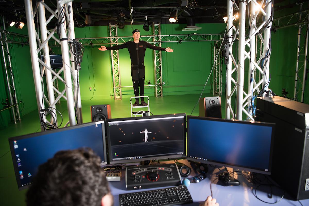 Student in front of a green screen in the GRID lab