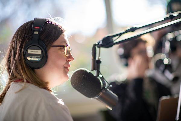 Girl with headphones talks into microphone