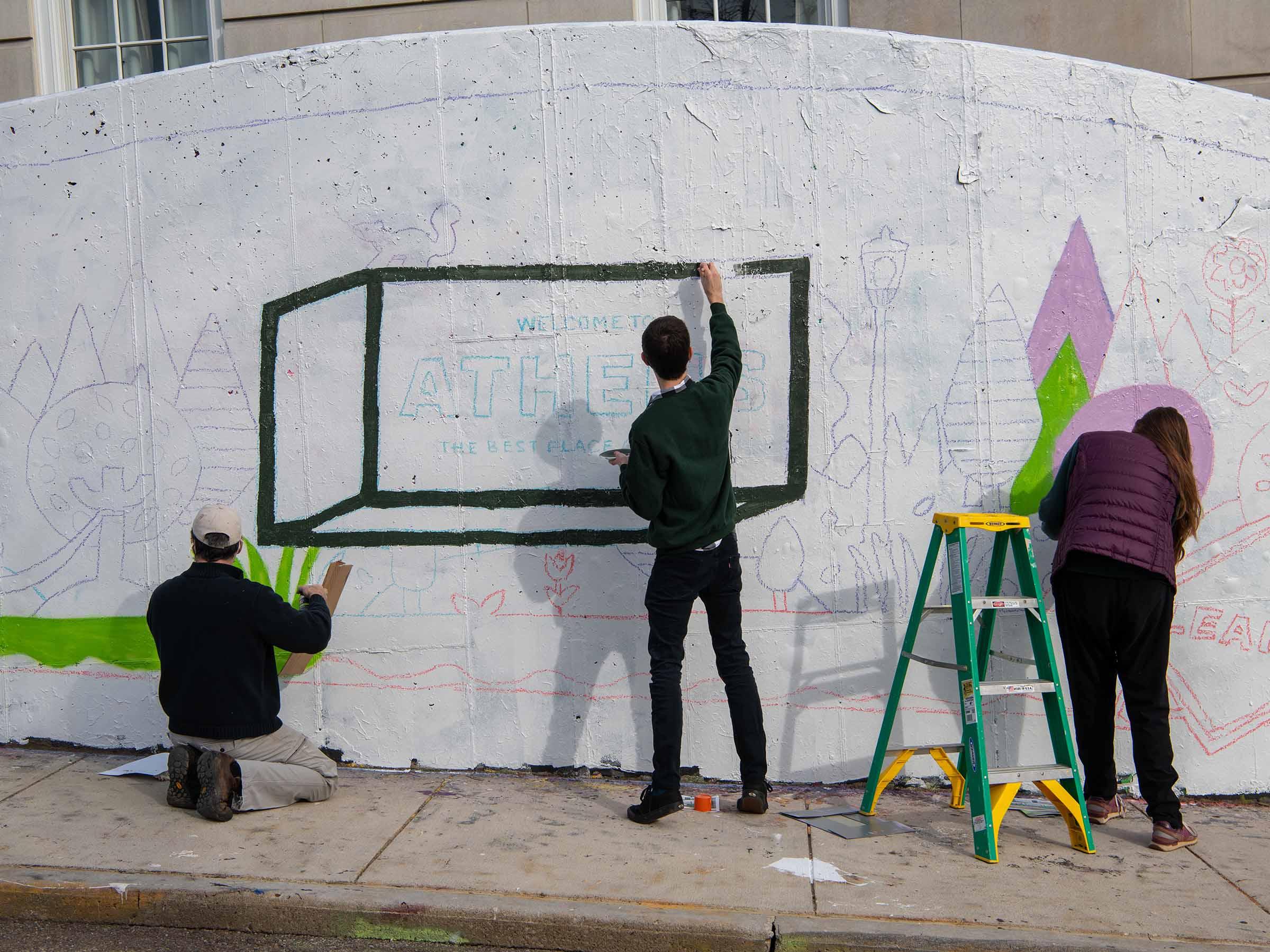 UCM staff members painting graffiti wall