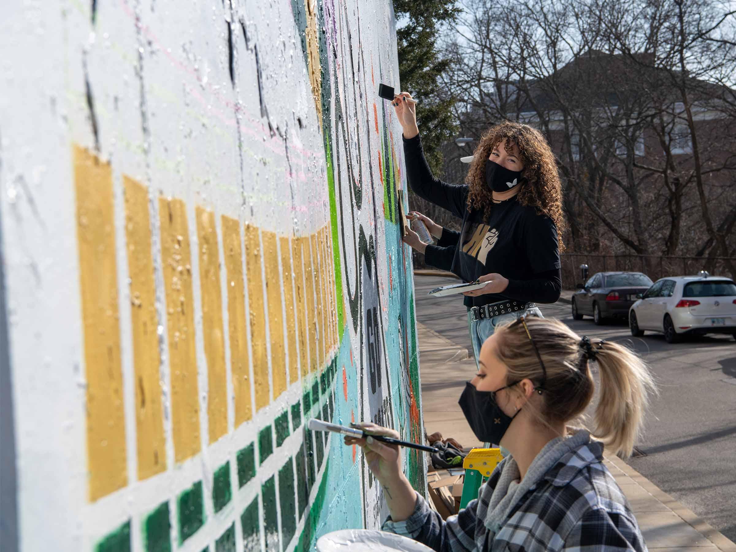 Two OHIO alumni painting Graffiti wall