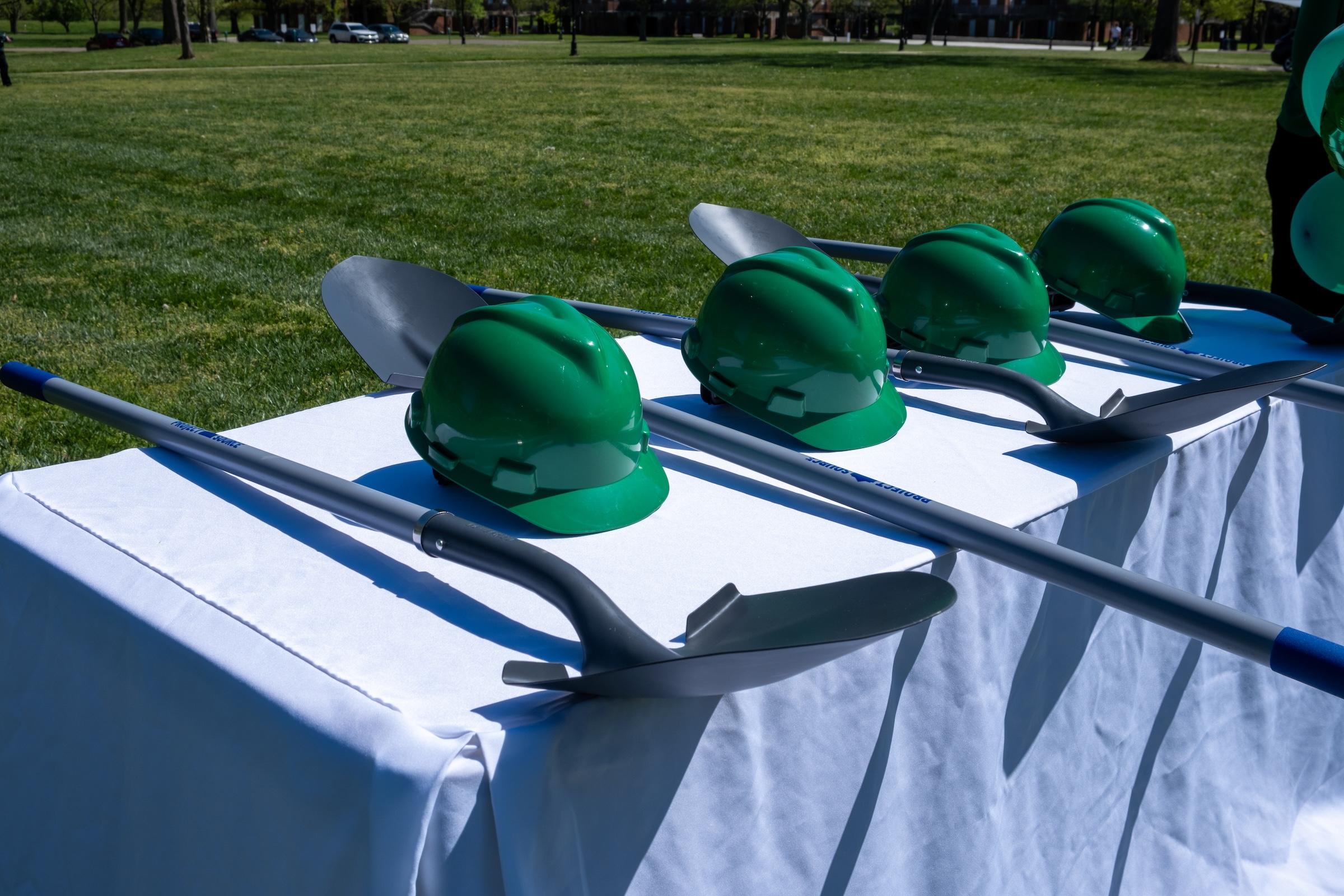 hard hats and shovels on a table