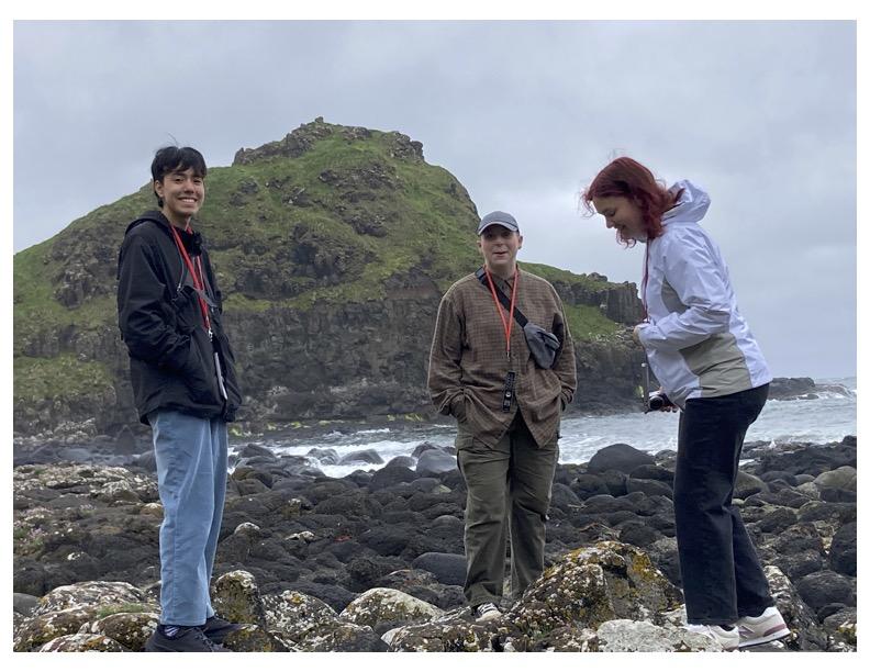 3 people standing on a rocky beach in Ireland