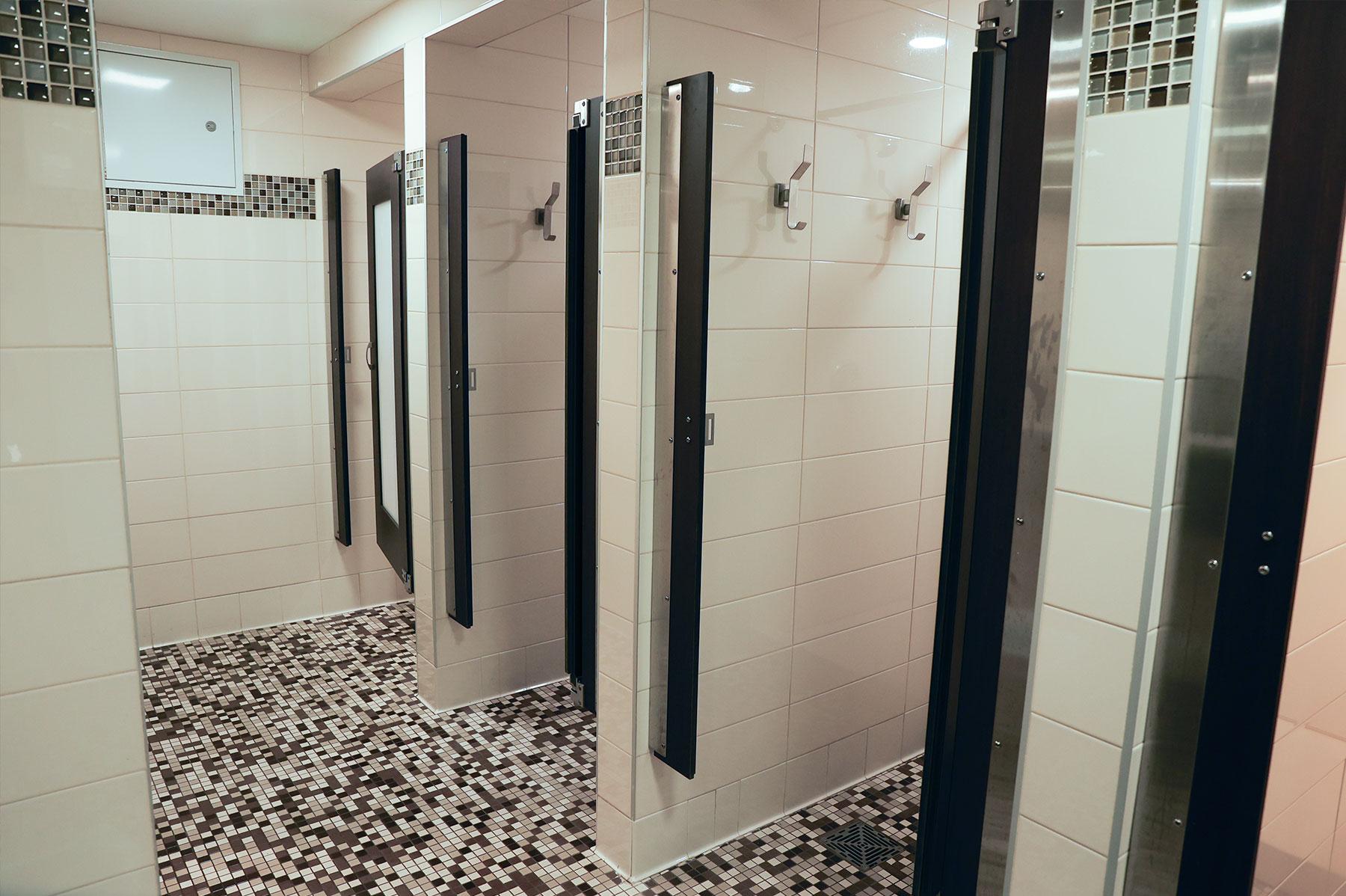 Inside Boyd Hall's bathrooms for students, showing individual shower stalls