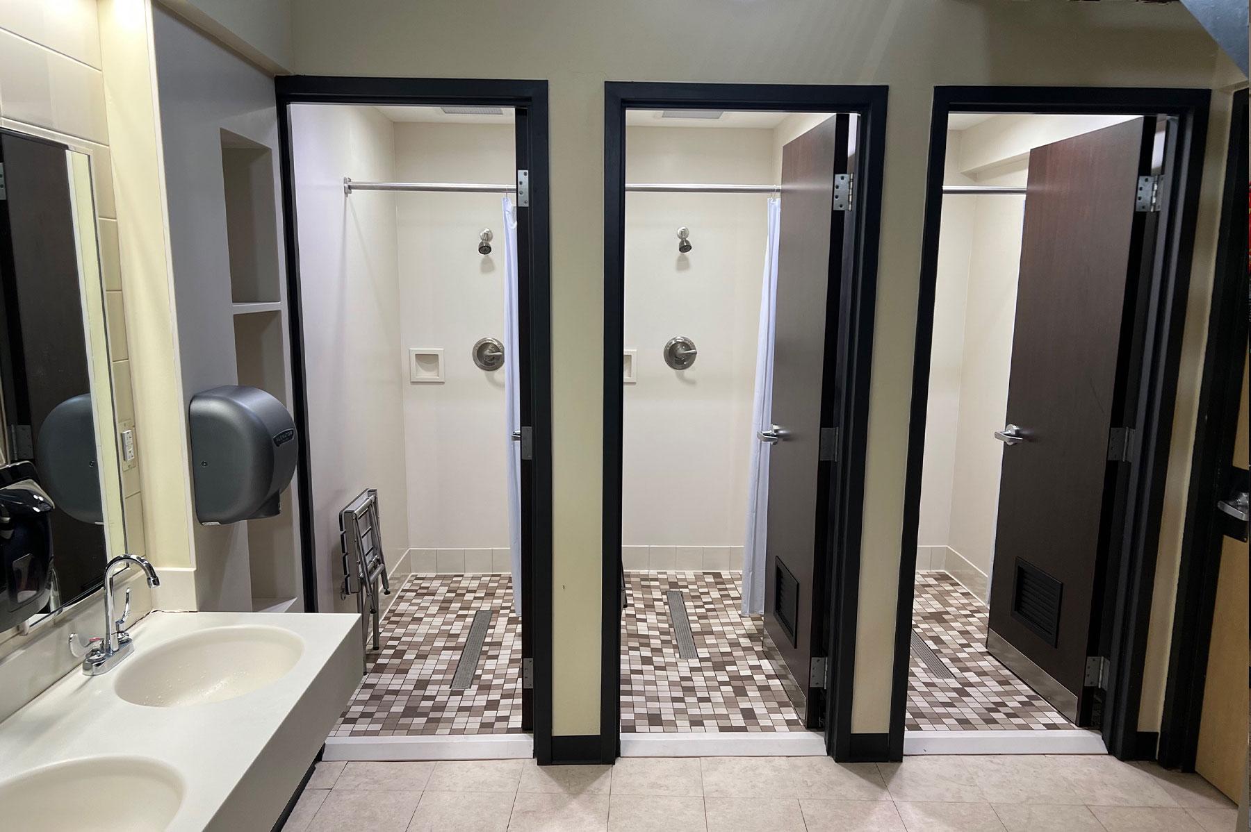 Inside a residence hall restroom in the Convocation Center, showing individual rooms for showers