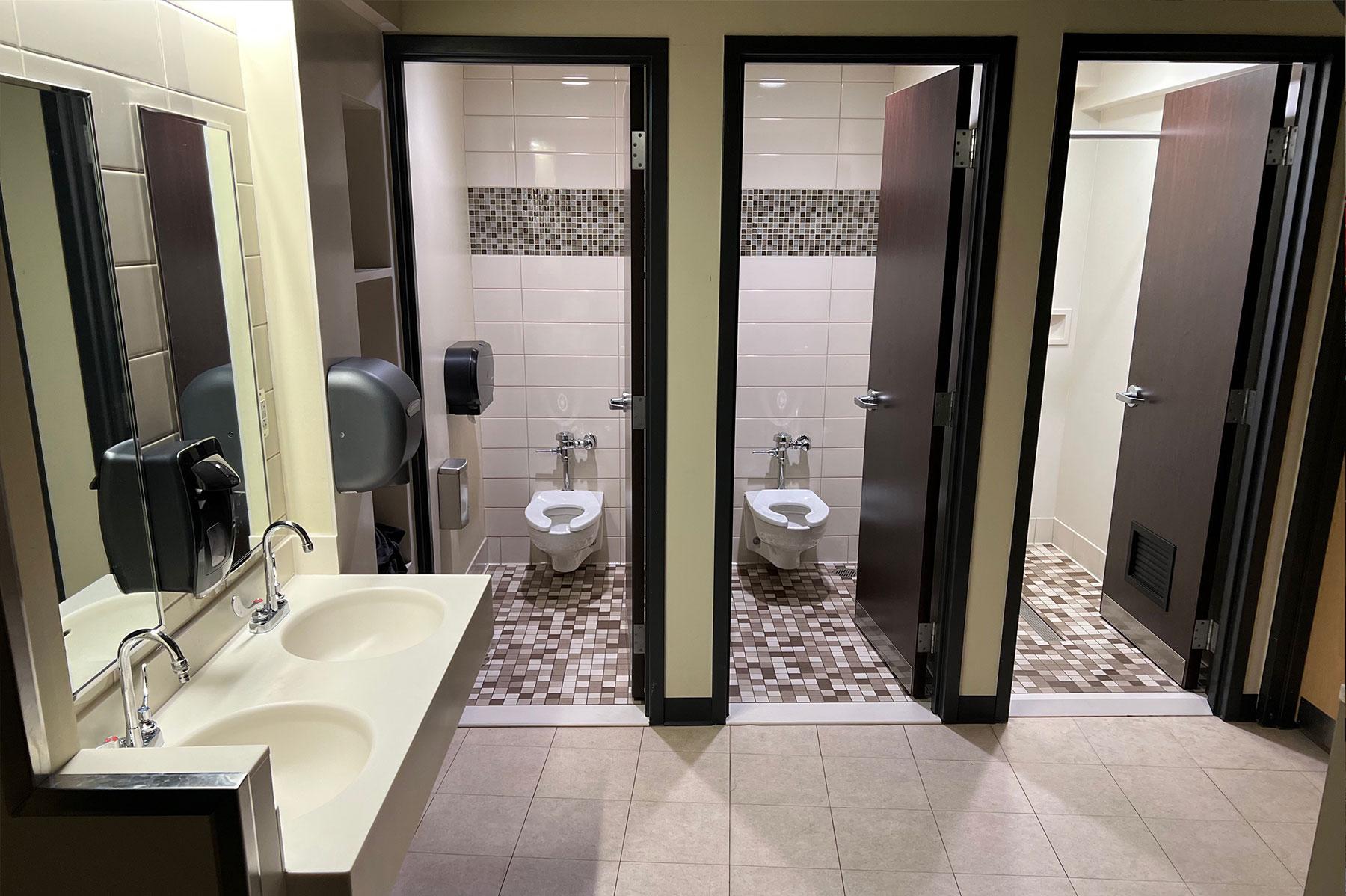 Inside a residence hall restroom in the Convocation Center, showing individual rooms for toilets